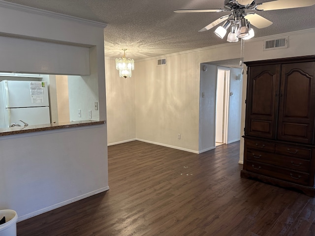 interior space featuring dark hardwood / wood-style floors, ceiling fan with notable chandelier, ornamental molding, and a textured ceiling