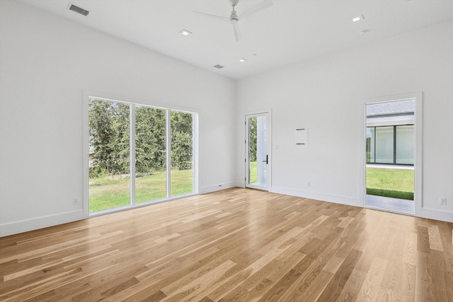 interior space featuring light hardwood / wood-style floors, a towering ceiling, and ceiling fan