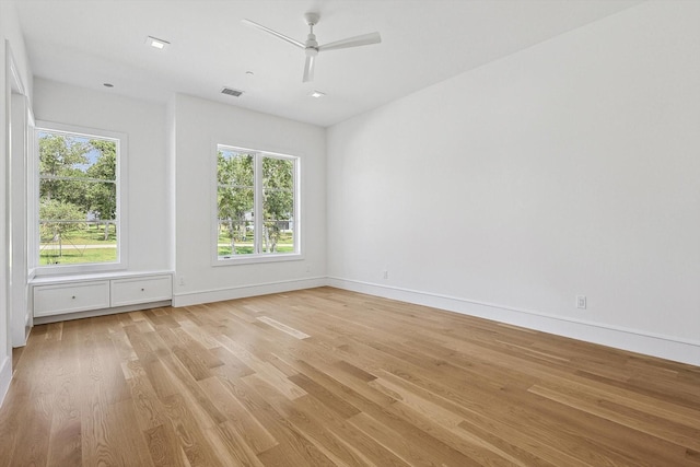 spare room with ceiling fan, a healthy amount of sunlight, and light wood-type flooring