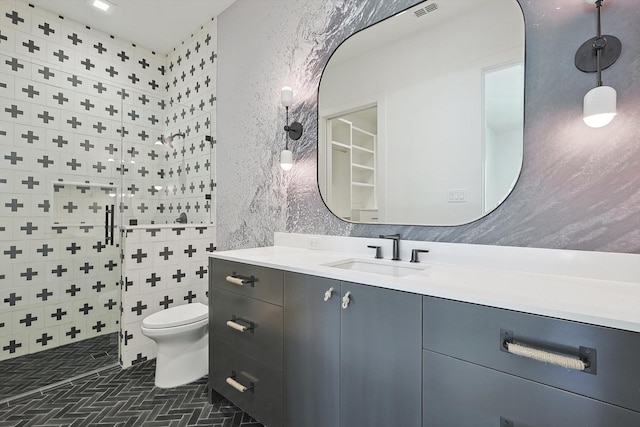 bathroom featuring toilet, a shower, and vanity