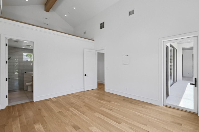 unfurnished bedroom with light wood-type flooring, ensuite bathroom, high vaulted ceiling, and beamed ceiling