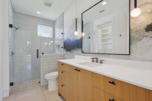 bathroom with toilet, tile patterned flooring, an enclosed shower, and vanity