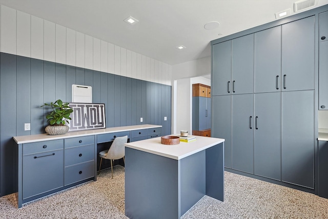 office area featuring built in desk and wooden walls