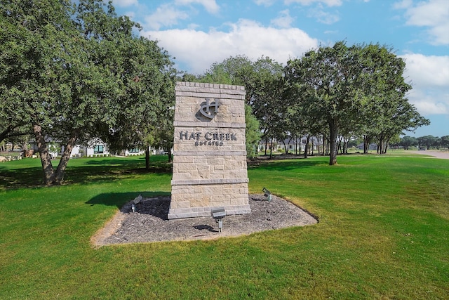 community / neighborhood sign with a yard