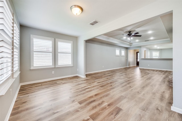 6726 Hickory Creek Dr, Frisco, TX 75036 - unfurnished living room with light wood-type flooring, visible vents, ceiling fan, crown molding, and a raised ceiling