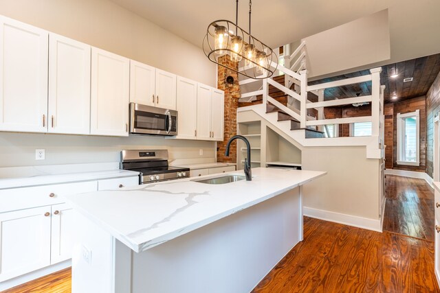 kitchen with dark hardwood / wood-style floors, a center island with sink, stainless steel appliances, and sink