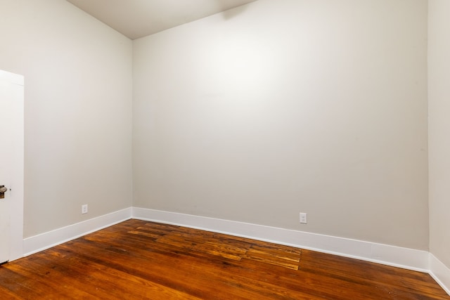 607 N Dallas St, Ennis, TX 75119 - spare room with vaulted ceiling, baseboards, and wood finished floors