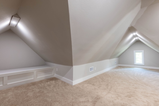 607 N Dallas St, Ennis, TX 75119 - bonus room featuring light carpet, vaulted ceiling, visible vents, and baseboards