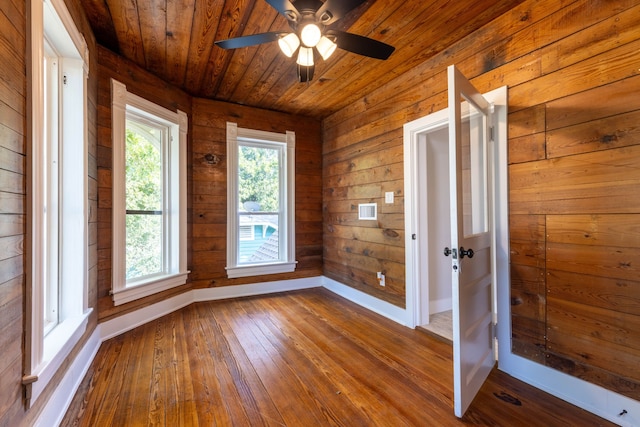 607 N Dallas St, Ennis, TX 75119 - empty room featuring baseboards, wood walls, ceiling fan, wood ceiling, and dark wood-type flooring
