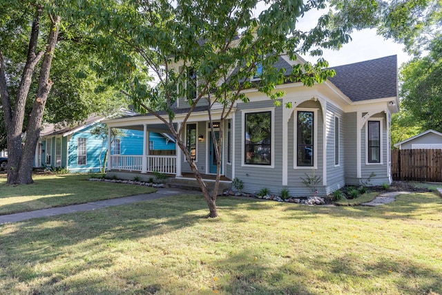 607 N Dallas St, Ennis, TX 75119 - view of front of property with covered porch, a shingled roof, a front lawn, and fence