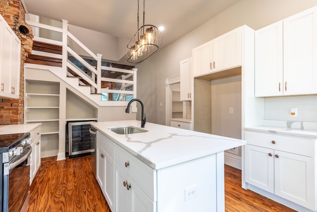 kitchen with sink, dark hardwood / wood-style flooring, stainless steel appliances, and a kitchen island with sink