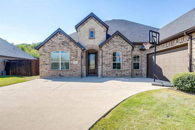 french country inspired facade featuring a front lawn and a garage