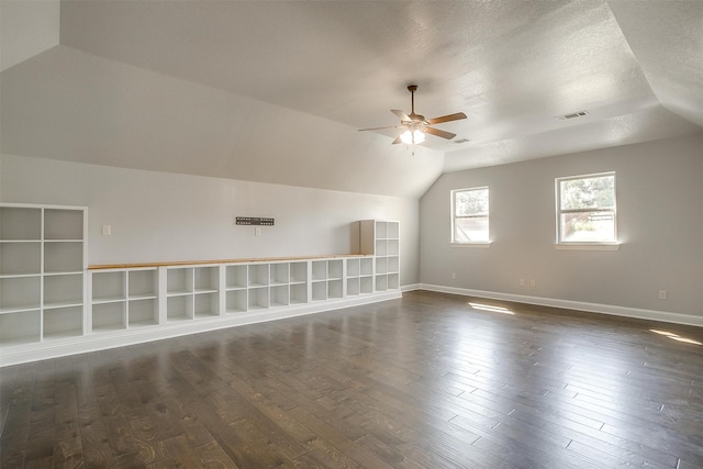 bonus room featuring ceiling fan, a textured ceiling, vaulted ceiling, and dark hardwood / wood-style floors