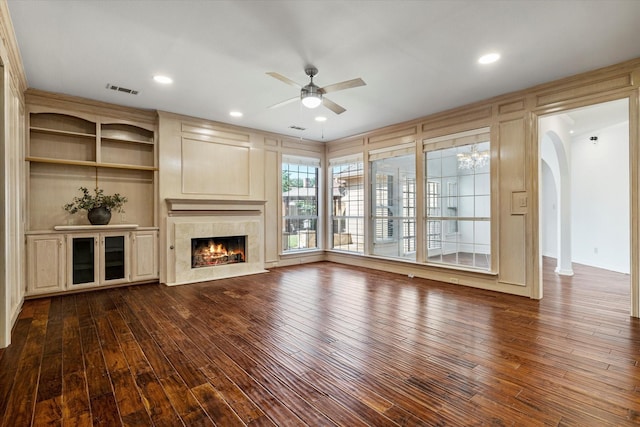 unfurnished living room featuring dark wood-style floors, visible vents, a fireplace, and ceiling fan