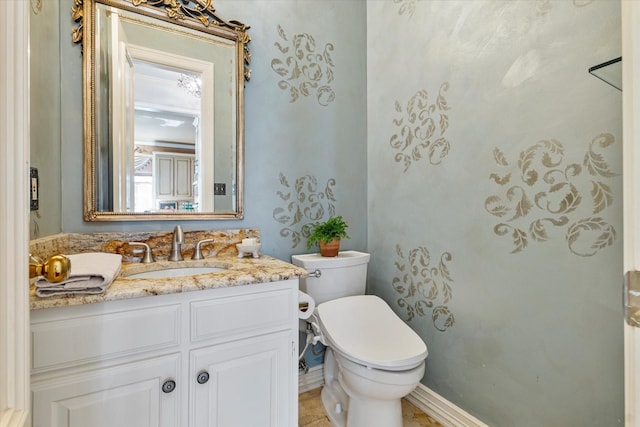 half bathroom with toilet, baseboards, and vanity