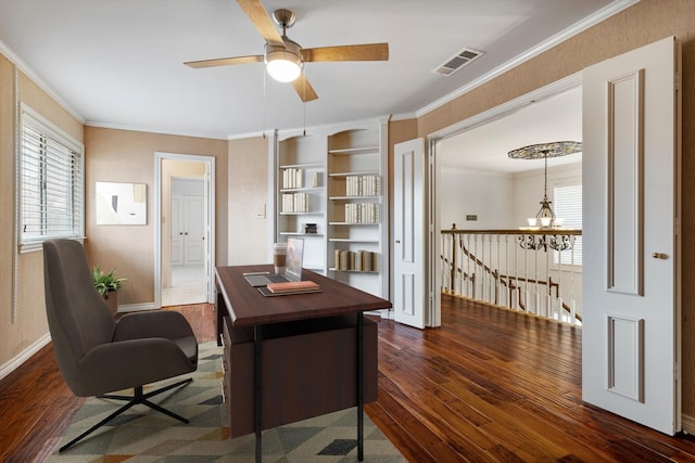 office space with baseboards, visible vents, dark wood-type flooring, crown molding, and ceiling fan with notable chandelier