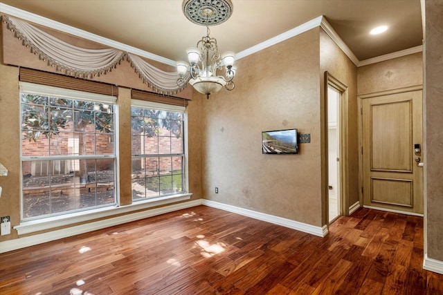 unfurnished dining area with dark wood-style floors, ornamental molding, an inviting chandelier, and baseboards