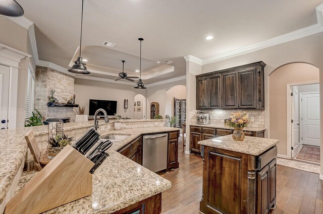 kitchen featuring a healthy amount of sunlight, stainless steel appliances, a center island, decorative backsplash, and dark brown cabinetry