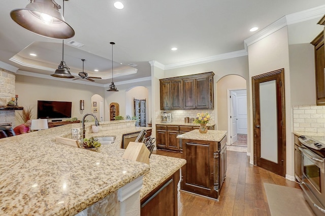 kitchen with ceiling fan, tasteful backsplash, a large island, and light hardwood / wood-style flooring