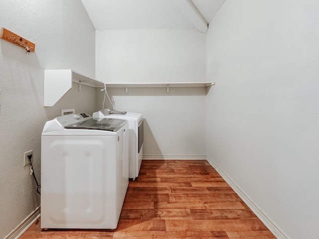 laundry room with separate washer and dryer and light hardwood / wood-style flooring