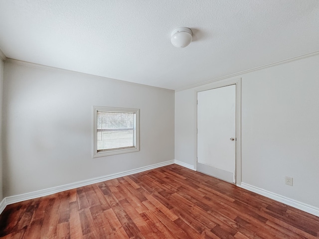 empty room with hardwood / wood-style floors and a textured ceiling