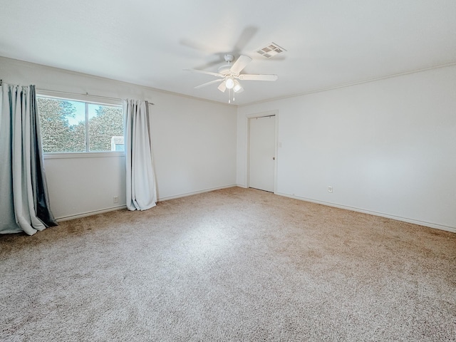 carpeted spare room featuring ceiling fan