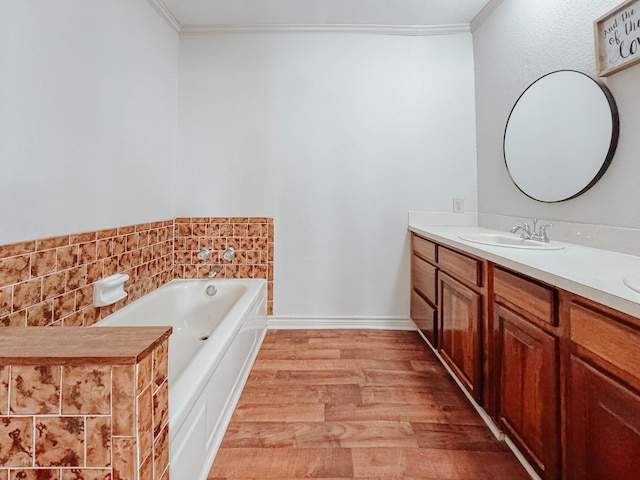 bathroom with crown molding, vanity, a bathing tub, and hardwood / wood-style flooring