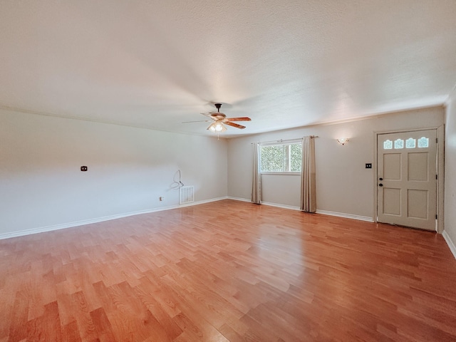 unfurnished living room with ceiling fan, light hardwood / wood-style flooring, and a textured ceiling