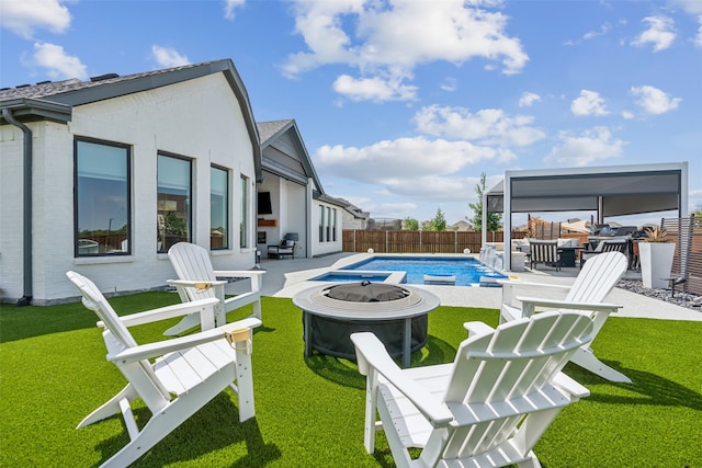 view of swimming pool with a fire pit, a yard, and a patio