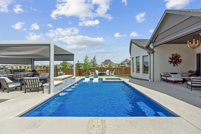 view of pool featuring outdoor lounge area, pool water feature, and a patio area