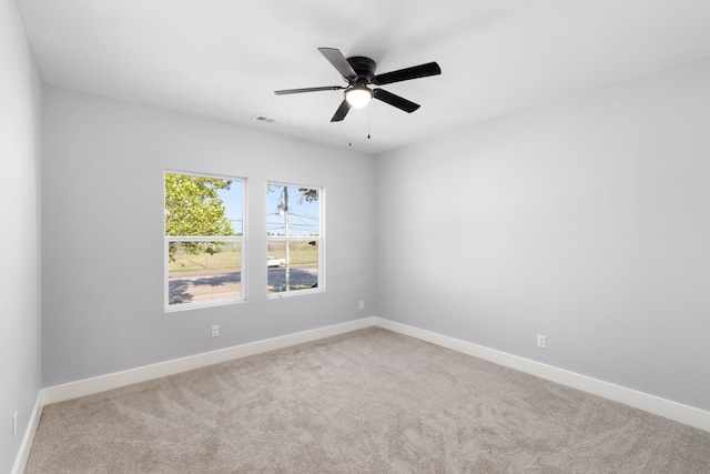 empty room featuring ceiling fan and light carpet