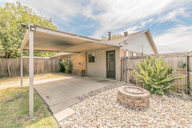 rear view of property with a patio and a fire pit