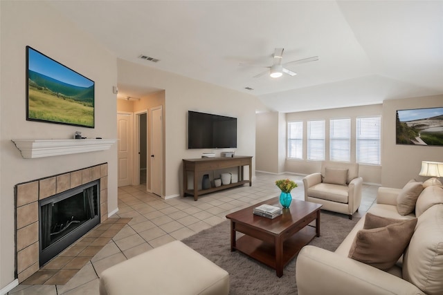 living room with a fireplace, vaulted ceiling, light tile patterned flooring, and ceiling fan