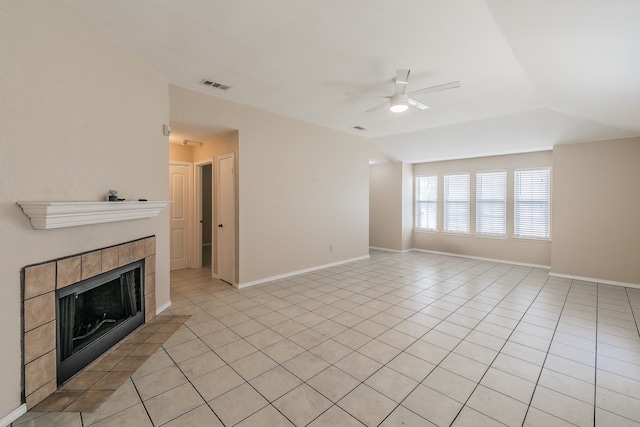 unfurnished living room featuring ceiling fan, light tile patterned flooring, and a tile fireplace