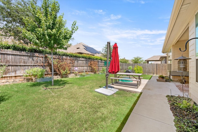 rear view of house with a patio area, a yard, and solar panels