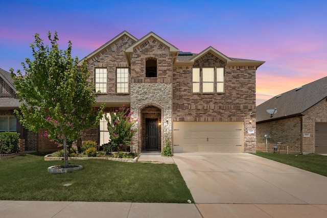 view of front of home featuring a garage and a yard