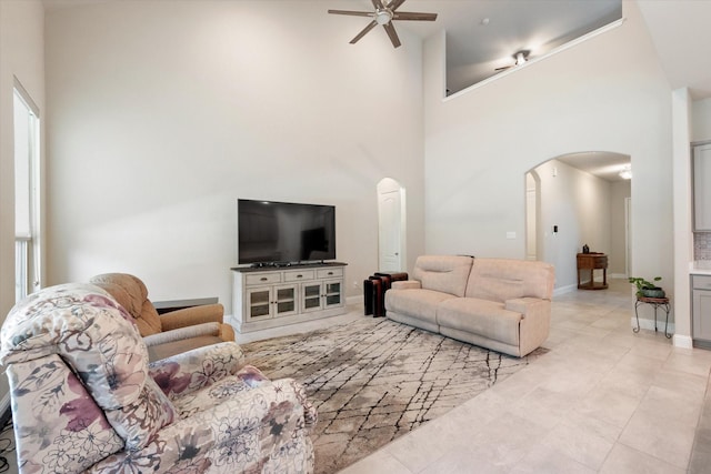 living room with ceiling fan and a high ceiling