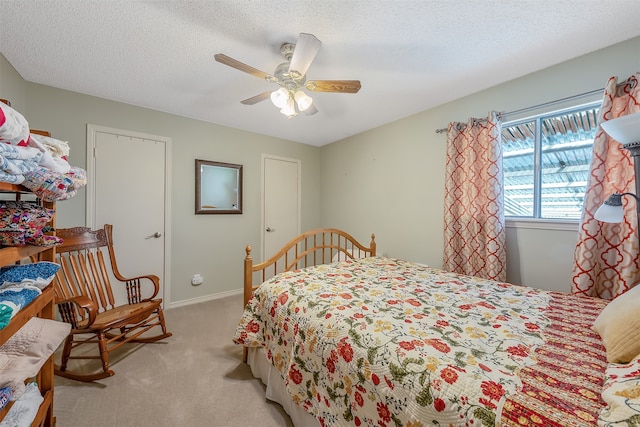 bedroom featuring light carpet, a textured ceiling, and ceiling fan