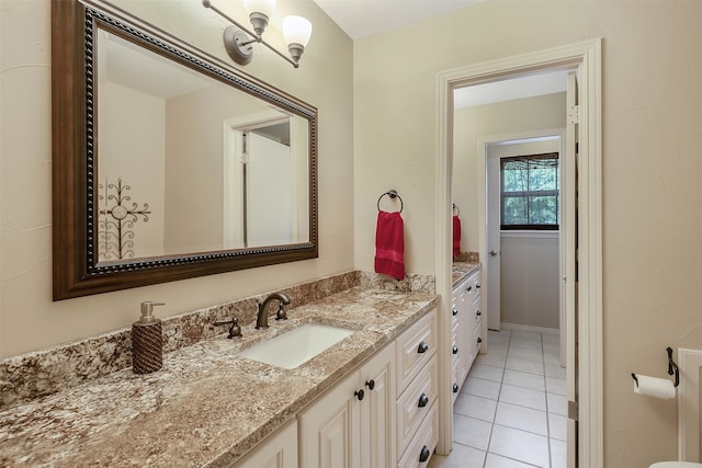 bathroom with tile patterned floors, vanity, and an inviting chandelier