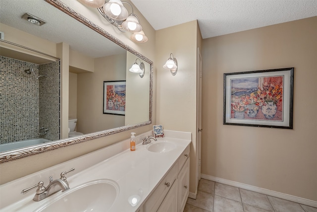 full bathroom featuring a textured ceiling, toilet, tiled shower / bath, tile patterned floors, and dual vanity