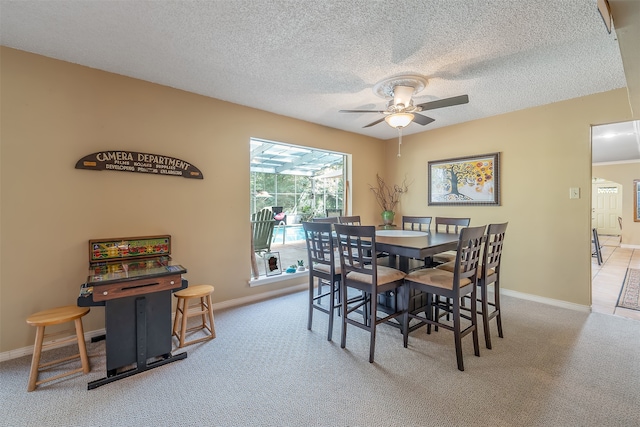 carpeted dining area with a textured ceiling and ceiling fan