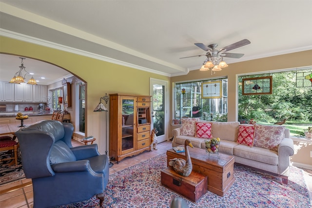 tiled living room featuring ceiling fan and crown molding