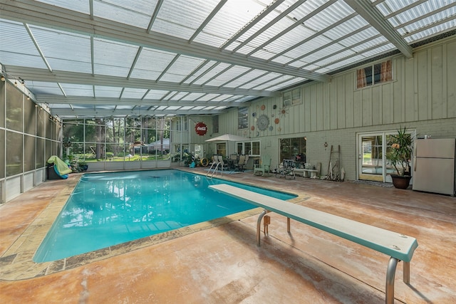 view of pool with a patio and a diving board