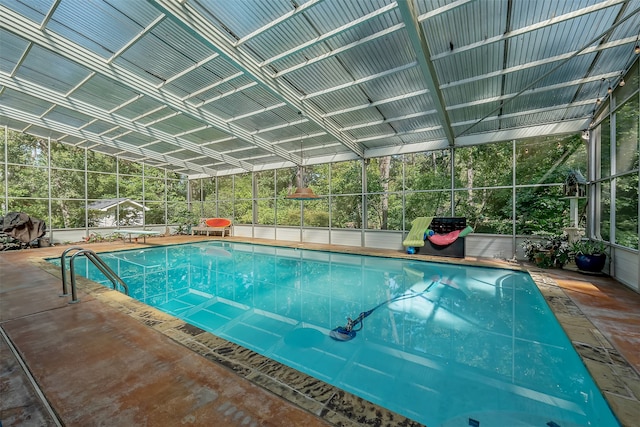 view of pool featuring glass enclosure and a patio area