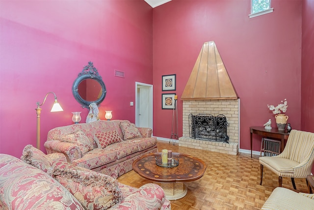 living room with parquet flooring, a fireplace, and a towering ceiling