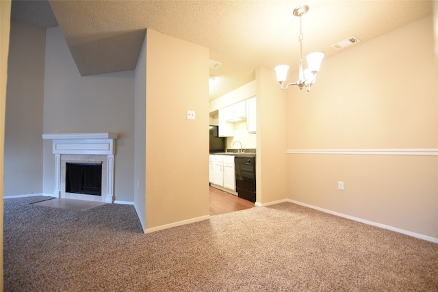 unfurnished living room featuring sink, an inviting chandelier, light colored carpet, and a tile fireplace