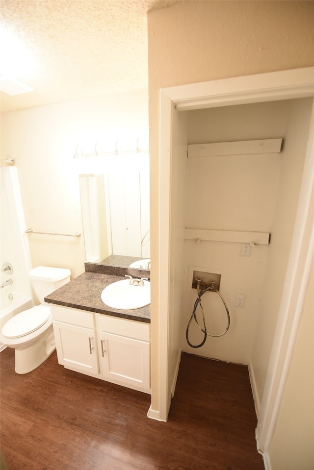 bathroom with a textured ceiling, vanity, toilet, and hardwood / wood-style floors