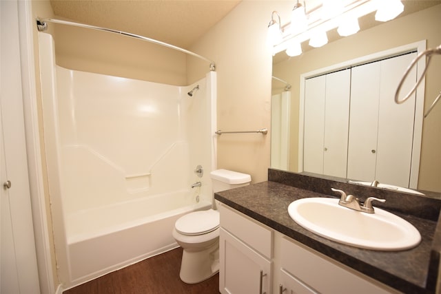 full bathroom with shower / bathtub combination, a textured ceiling, hardwood / wood-style floors, toilet, and vanity