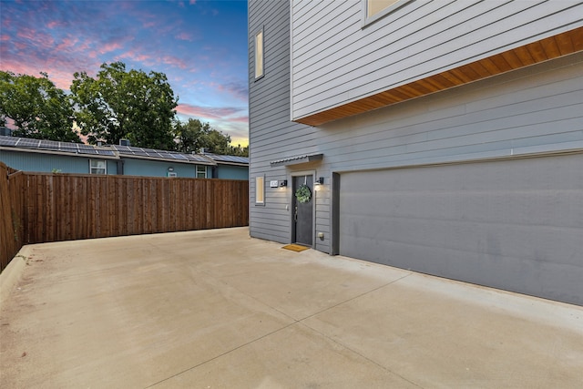 view of garage at dusk