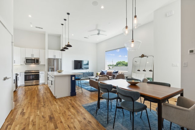 dining area with ceiling fan and light wood-type flooring